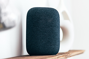 Altavoz inteligente de color negro en una estantería.