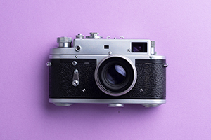 Cámara vintage sobre fondo morado.